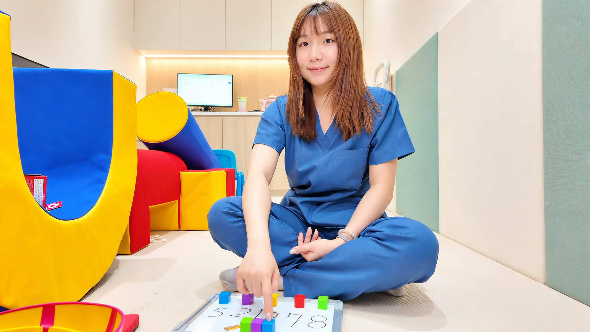 職能治療師在兒童治療室陪孩子做數字排序