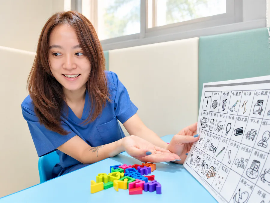 語言治療師用溝通圖板和積木陪孩子練習
